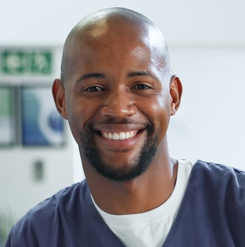 Black man and nurse in hospital scrubs, working together in a healthcare setting